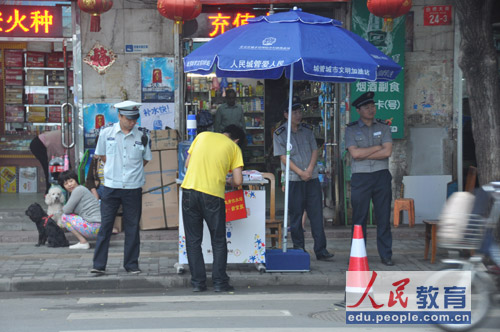 8日一早，广渠门中学考点，城管正在为家长考生搭建服务站。（摄影 熊旭）