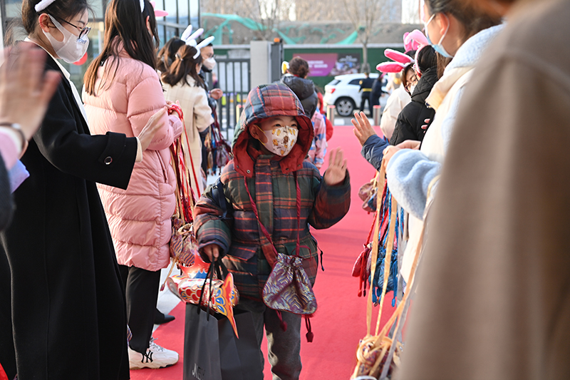 2月13日，昌平區北京十一未來城學校的老師們歡迎同學們回到校園，他們給每位學生都挂上一個福袋，希望把一年的福氣都送給學生們。昌平區北京十一未來城學校供圖
