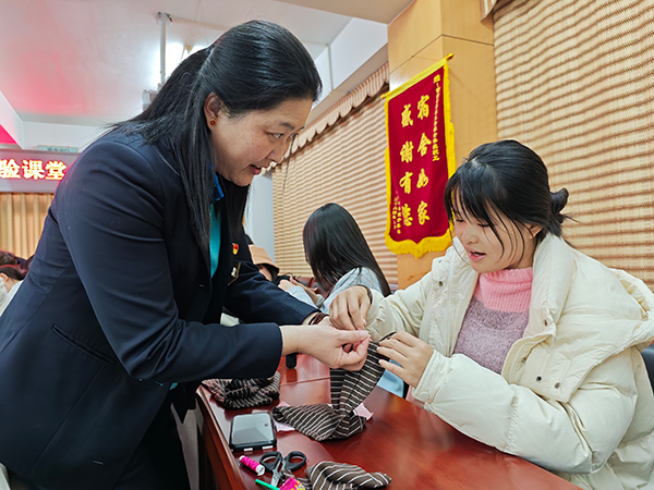學生在老師指導下，體驗縫補收納。