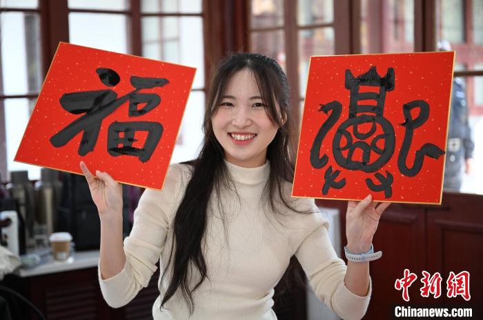 1月20日,馬來西亞留學生展示其創作的福貼。當日,來自巴西、馬來西亞、加納、哈薩克斯坦的外籍留學生在浙江杭州西泠印社體驗福貼、春聯和篆刻,感受古老的中國傳統文化。中新社記者 王剛 攝