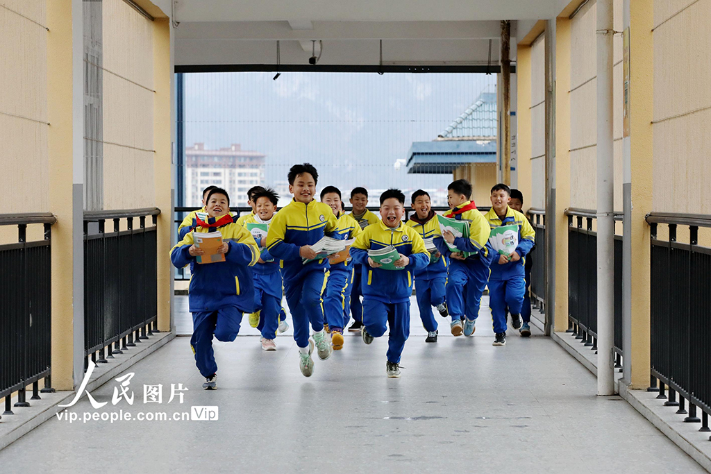 2026年3月2日,在貴州黔東南苗族侗族自治州施秉縣第四小學,學生領到新課本后開心地奔跑。邰勝智攝(人民圖片網)