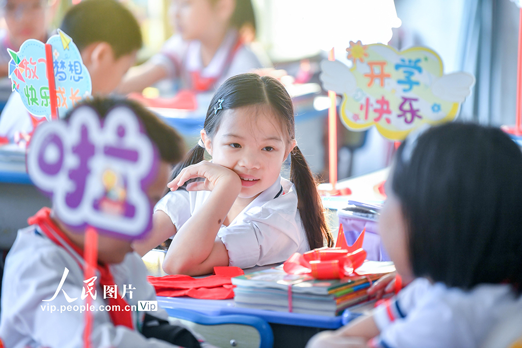 2026年3月1日,海南海口市中小學校學生返校報到。在海口市港灣小學,學校將新課本打包成“新學期禮物”,並為同學們發放嶄新的紅領巾。蘇弼坤攝(人民圖片網)