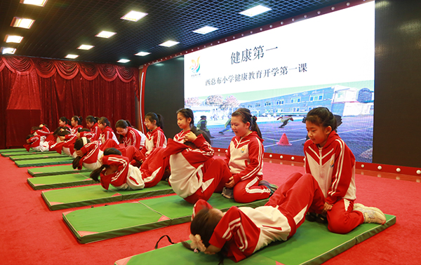北京市東城區西總布小學的學生們正在做仰臥起坐。學校供圖