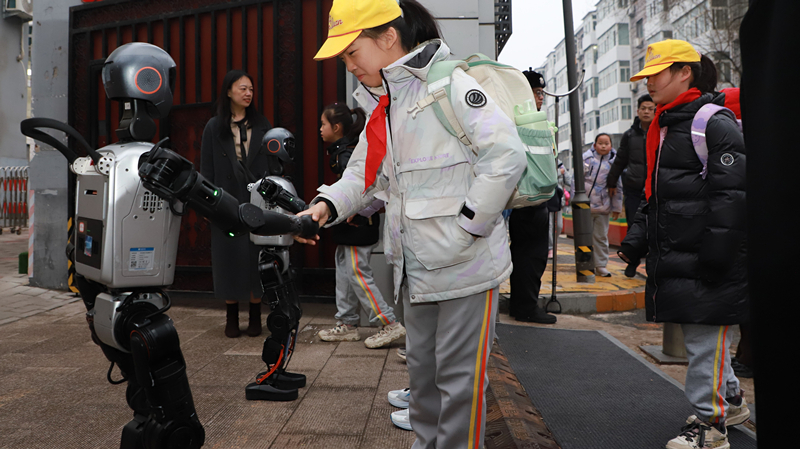 北京市東交民巷小學機器人在學校門口熱情迎接同學們返校。校方供圖