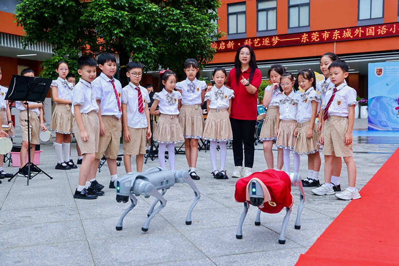 东莞市东城外国语小学“开学嘉年华”活动中师生与机器狗互动。校方供图