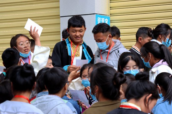 老师给学生们分发毕业合照。扎西旺久摄