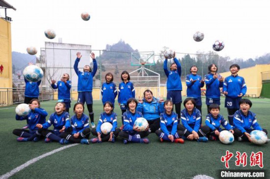 图为12月9日,“元宝女子足球队”教练徐召伟(中)和部分队员合影。 瞿宏伦 摄