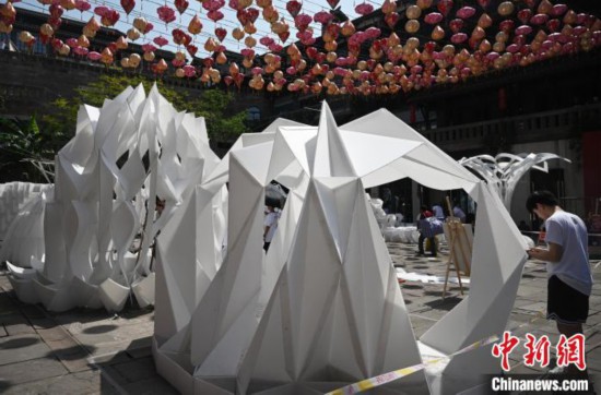 一位學生正在檢查搭建的建筑作品。　周毅 攝