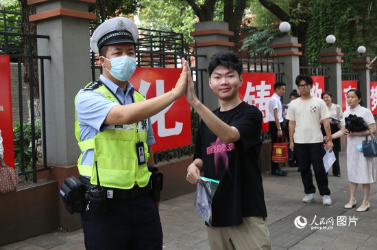 6月7日8時許，武漢中學考點門口，交警在維護秩序，並祝考生金榜題名。人民網記者 肖璐欣攝