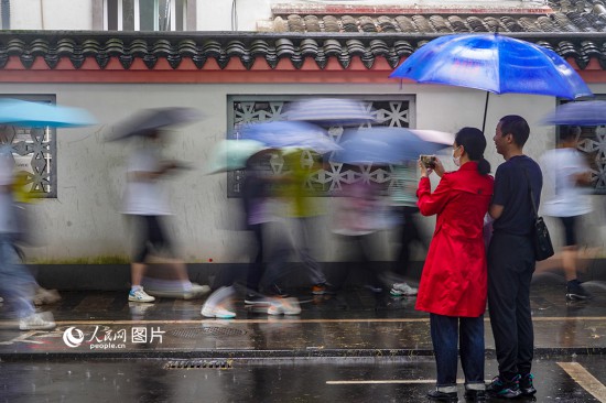 6月7日，在浙江省2023年普通高校招生考試鎮海中學考點，家長冒雨目送子女進入考場。人民網 章勇濤攝