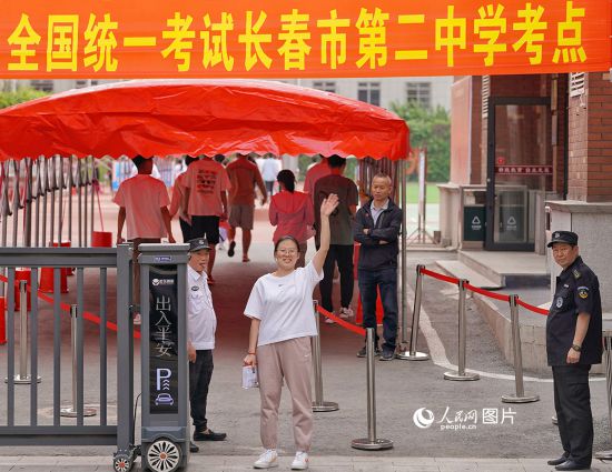 6月7日，在長春市第二中學考點，一名考生信心滿滿進入考場，並與家長揮手致意。人民網記者 李洋攝