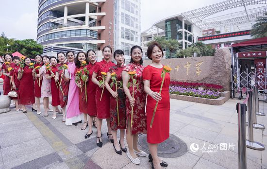 6月7日一早，廈門雙十中學考生家長們身穿旗袍，手拿向日葵在考場外為孩子加油打氣，寓意“旗開得勝，一舉奪魁”。人民網記者 陳博攝