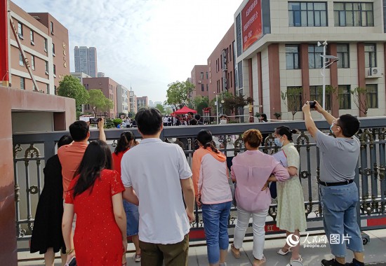 6月7日，武漢市第三中學考點，考生進場后，家長在柵欄外用手機拍攝自己的孩子。人民網記者 郭婷婷攝