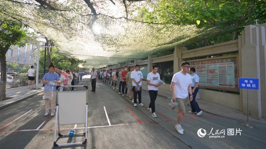 6月7日，烏魯木齊市第七十中學門口，考生們有序進入考場。人民網 李欣洋攝