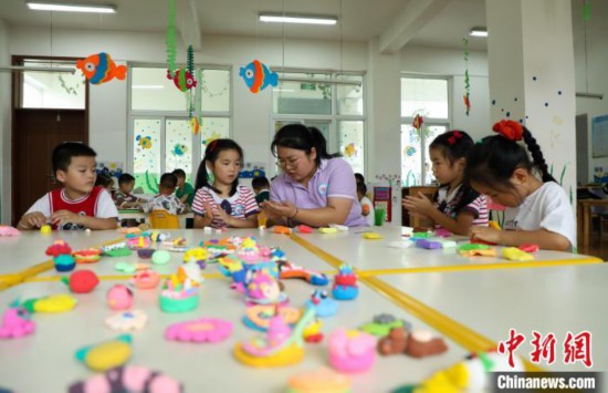 在肥西縣山南鎮中心幼兒園,孩子們在老師的指導下做彩色泥塑。 陳家樂 攝