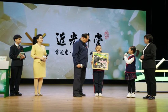 平谷六小版畫社團的學生代表贈送手工作品《平谷彩韻》，展現了平谷桃花海美景。