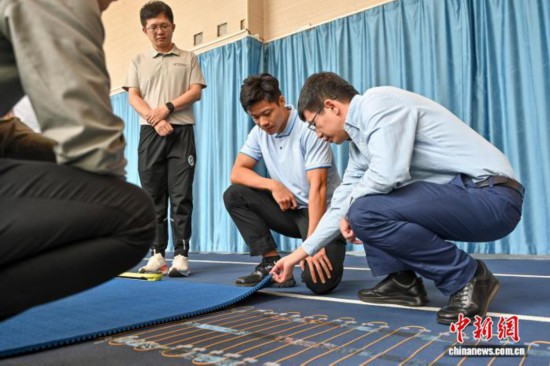 圖為蘇炳添在訓練基地內了解數字化跑道分析系統。中新社記者 陳驥旻 攝